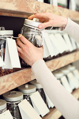 Kobieta wybiera rodzaj herbaty podczas zakupów w sklepie herbacianym - obrazy, fototapety, plakaty
