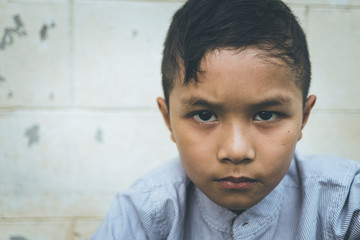 scared and alone, young Asian child who is at high risk of being bullied, trafficked and abused