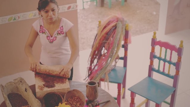 Indigenous woman grind cacao seeds to make chocolate old way in Mexico
