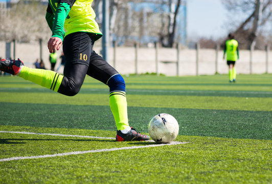 Detail image of a woman soccer player's leg when is kicking the ball