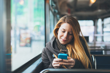 Young woman using smartphone in public transport