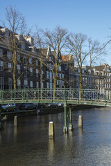 Green modern pedestrian bridge in Amsterdam brown houses