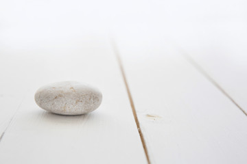 One white stone on a wooden table