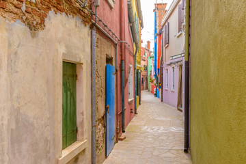 Colorful apartment buildings at very narrow street in Burano, Venice, Italy.