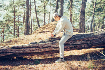 Sporty man tying shoelaces in the forest