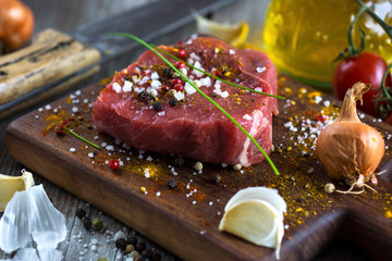 Fresh raw beef steak on wooden background