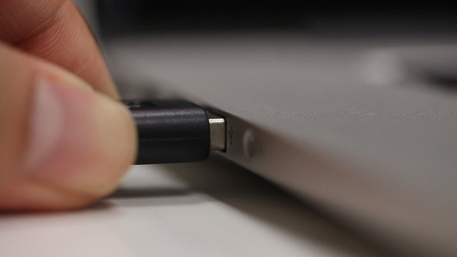 hand connecting USB port to laptop