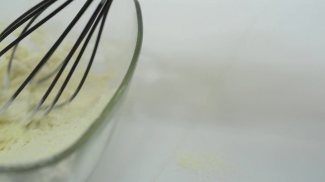 Whisking egg flour and milk in a glass bowl