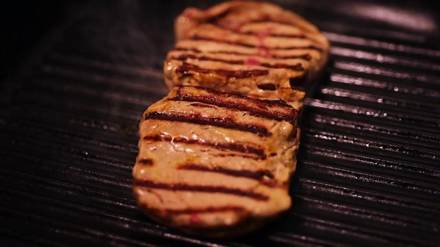 Steak frying in a griddle pan