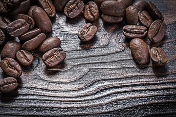 Roasted coffee beans on vintage wood board food and drink concep