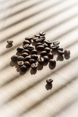 Coffee seeds on white table with shadows from the blinds