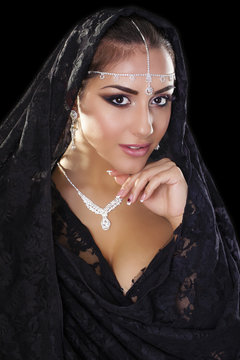 Portrait of a beautiful woman with arabian makeup in black paran