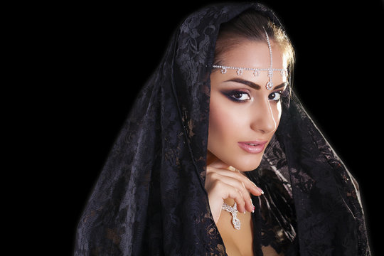 Portrait of a beautiful woman with arabian makeup in black paran