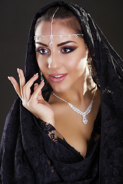Portrait of a beautiful woman with arabian makeup in black paran