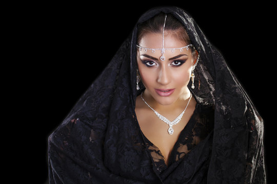 Portrait of a beautiful woman with arabian makeup in black paran