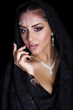 Portrait of a beautiful woman with arabian makeup in black paran