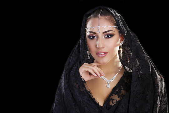 Portrait of a beautiful woman with arabian makeup in black paran