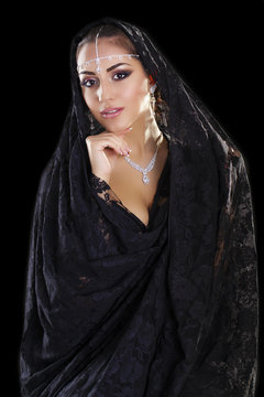 Portrait of a beautiful woman with arabian makeup in black paran