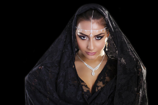 Portrait of a beautiful woman with arabian makeup in black paran