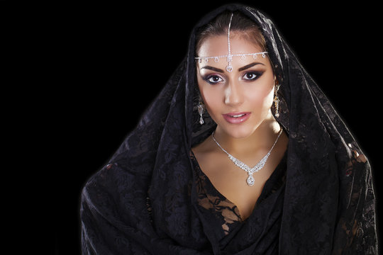 Portrait of a beautiful woman with arabian makeup in black paran