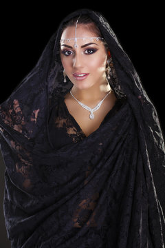 Portrait of a beautiful woman with arabian makeup in black paran