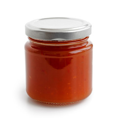 Closed glass jar of red chilli pepper sauce. Isolated.