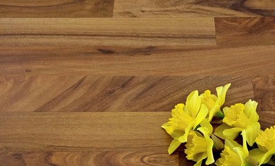 yellow daffodils in the corner of the wooden floor