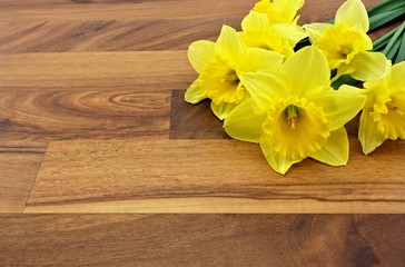 yellow daffodils in the corner of the wooden floor
