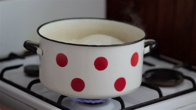 boiling milk/on a gas stove boiling milk in a saucepan on the stove and flows