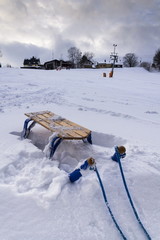 Blue childrens sleigh with ski lift in snowy country