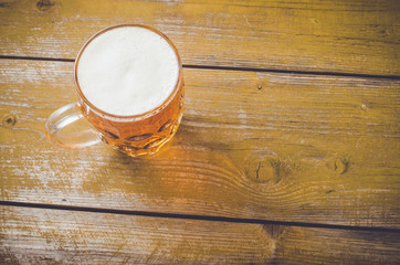 Beer glass on an old yellow wooden table. Close up