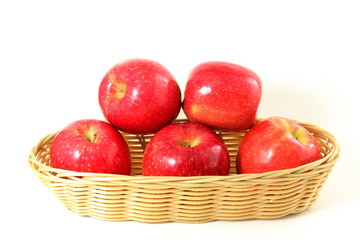 red apple in bamboo basket on white background