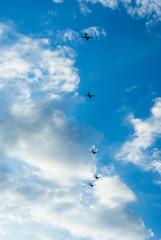 Five aircraft formation flying in the sky among the clouds