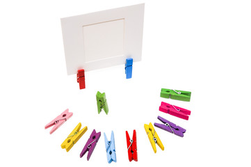 Clothespin is standing. Colored pegs lie in a semicircle. Two cl