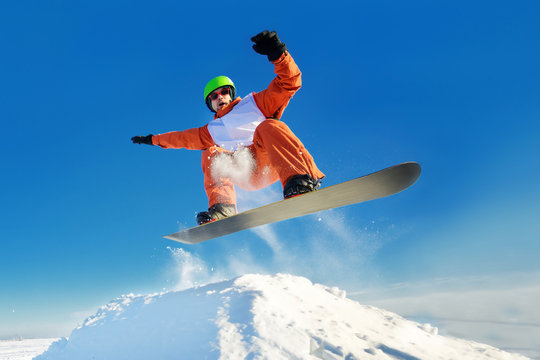 Snowboarder jumping blue sky in background