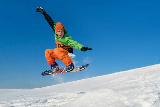 Snowboarder jumping blue sky in background