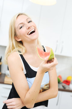 Blonde Frau isst eine Wassermelone