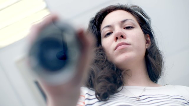 Beautiful young girl puts print stamp on office glass table. shoot from below