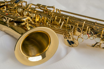 beautiful golden saxophone on delicate White silk background