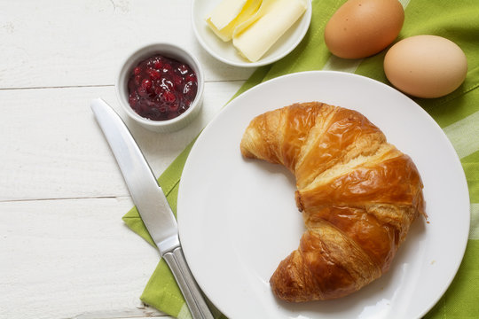 Sunday Breakfast With Croissant, Jam And Egg, Green Napkin On White Painted Wooden Table, Copy Space