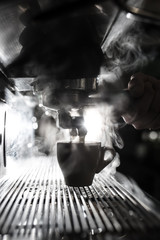 silhouette of coffee making process; espresso cup and coffee machine