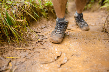 Male muddy hiking boot on mud