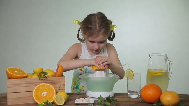 Girl squeezes out juice of a grapefruit