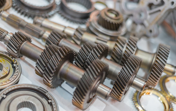 Selective Focus On Shiny Gears And Shafts On White Floor