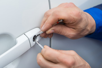 Hand Holding Lockpicker To Open Car Door