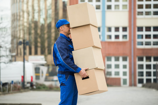 Delivery Man Balancing Stack Of Boxes