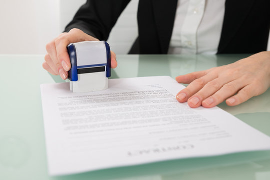 Businesswoman Stamping Contract Paper
