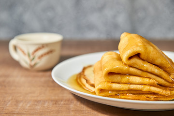 Pancakes with honey on white plate.