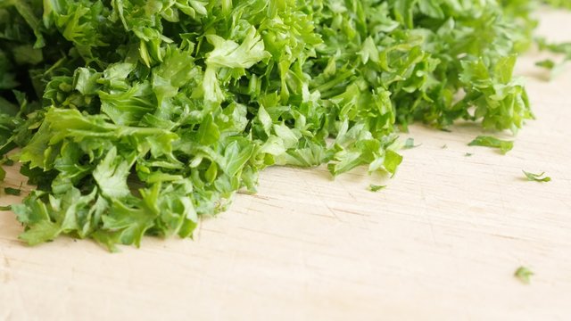 Parsley vegetable plant smaller pieces on cutting board 4K 3840X2160 UltraHD footage - Petroselinum crispum plant on cutting board 4K 2160p UHD video 