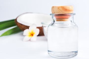coconut oil in a bottle, background is a half of coconut, isolated